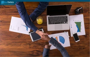 Business professionals shaking hands over a laptop, symbolizing collaboration and credit repair strategies for better scores.