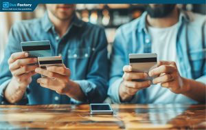 Two men holding multiple credit cards while using their smartphones for a transaction or online shopping.